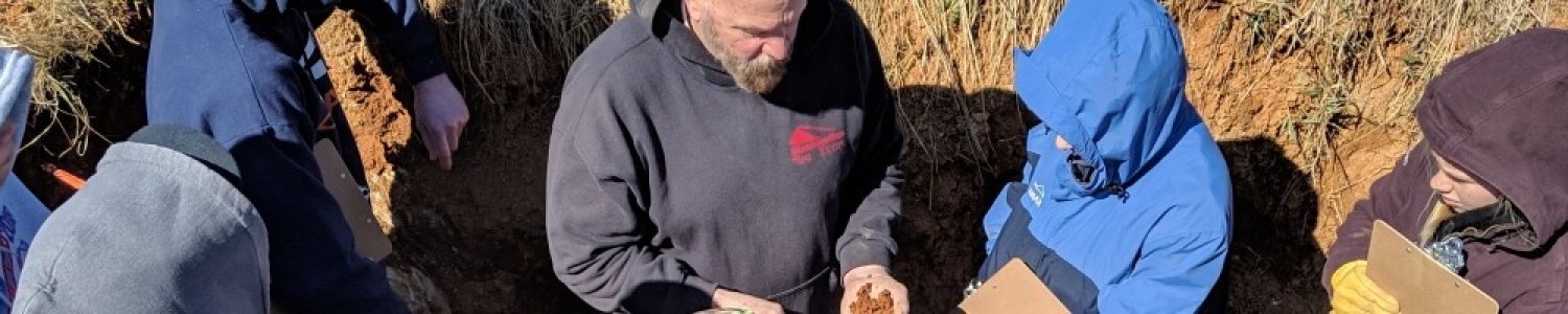 High school students are touching soil to learn about the texture of soil components