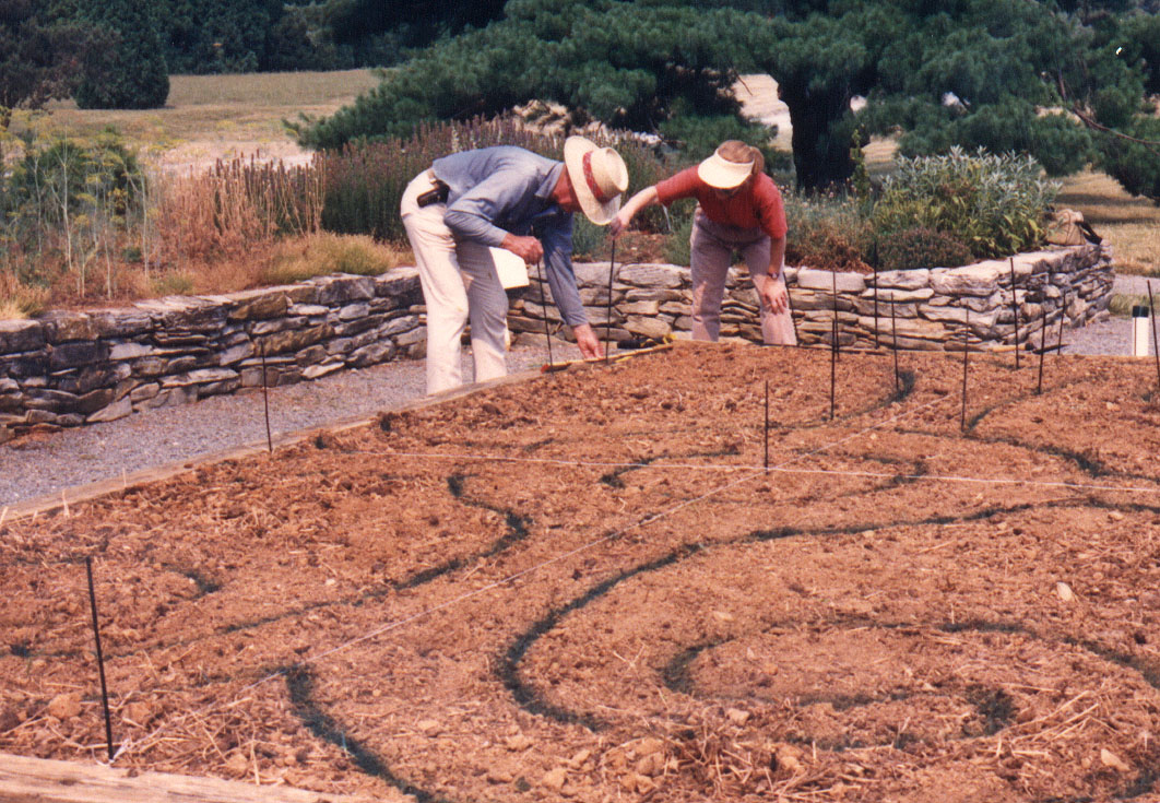 Two People working on a half completed garden bed in the herb garden