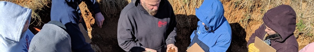 High school students are touching soil to learn about the texture of soil components